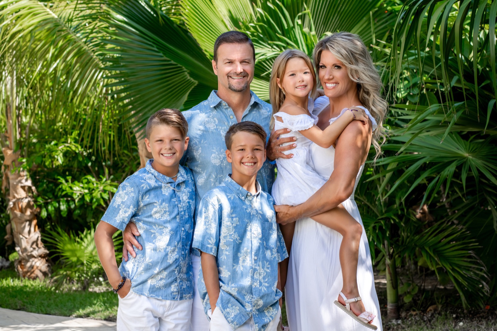 Retrato de familia completa posando junta al atardecer en la Zona Hotelera de Cancún
