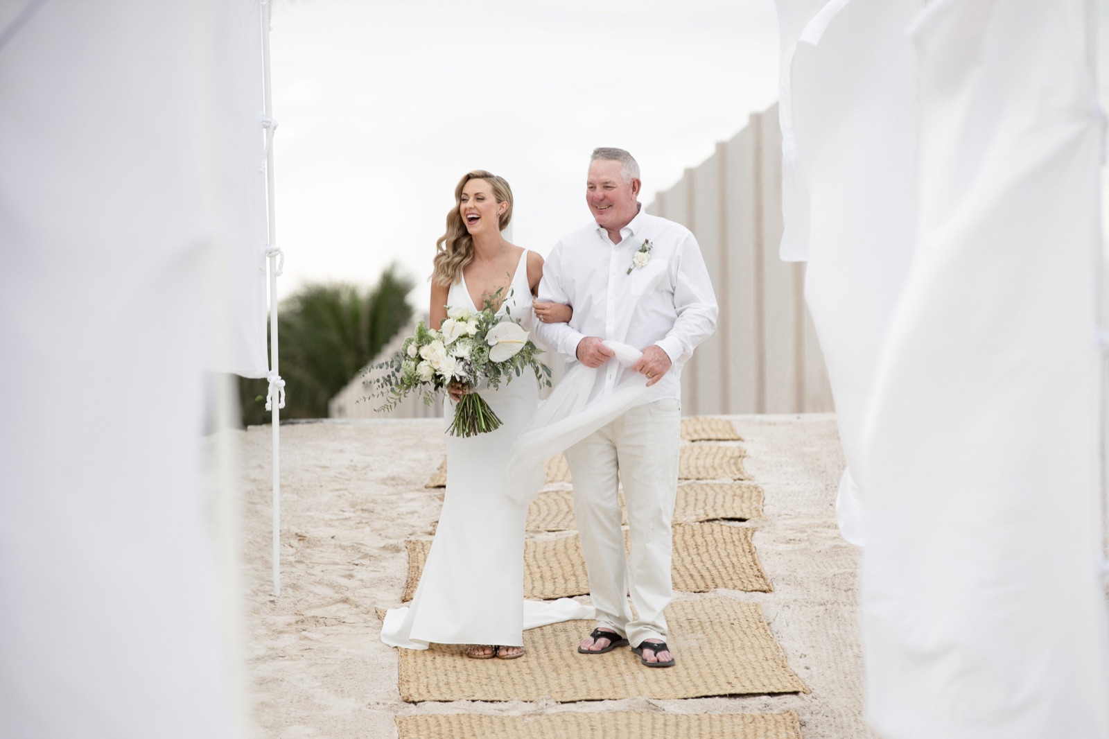 Bride on a Cancun beach with the open Caribbean behind her, the kind of wide coastal frame couples hope a drone will deliver