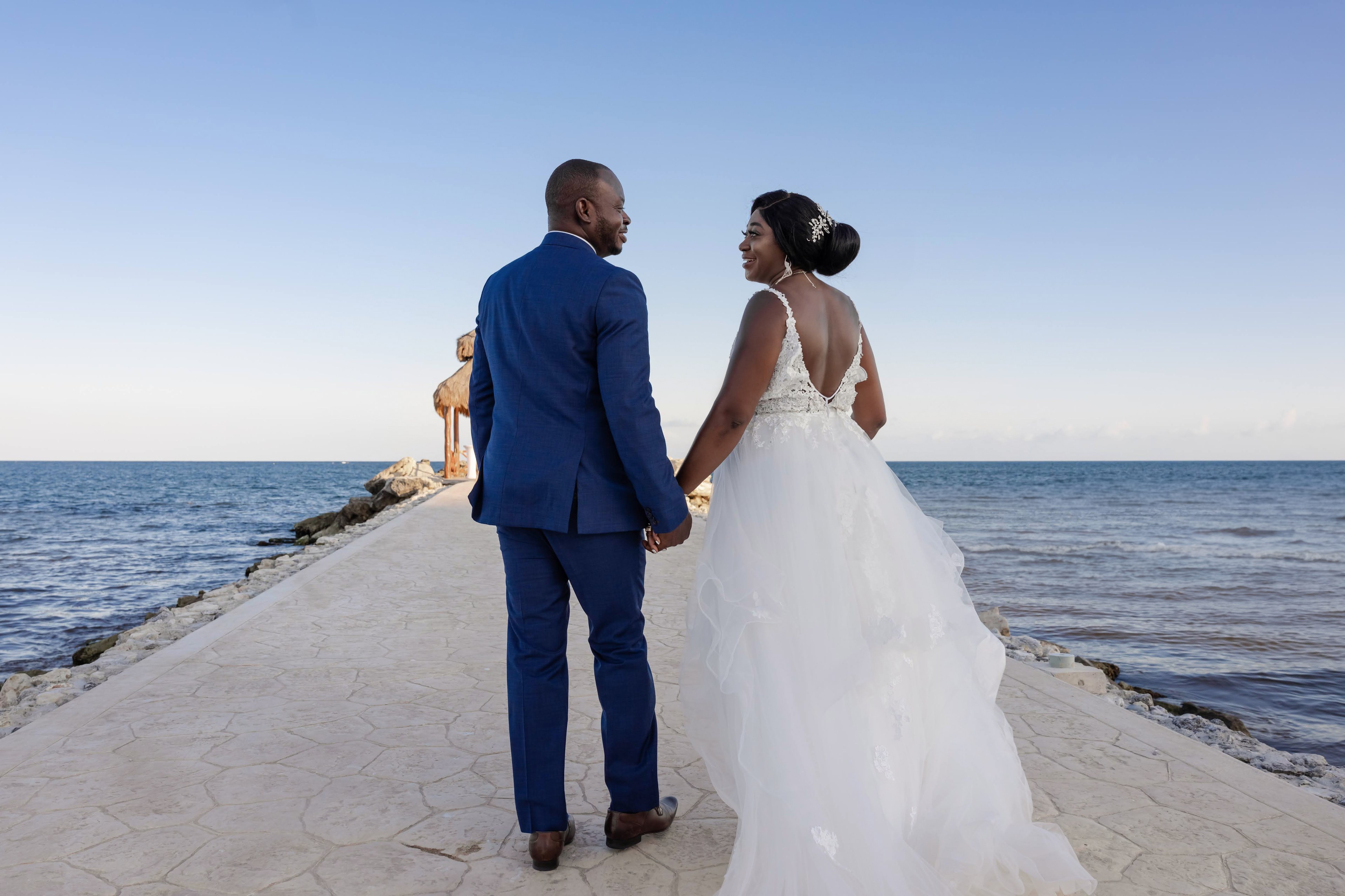 IVAE Studios destination wedding couple at golden hour on a Cancun beach in the Riviera Maya, Mexico, illustrating travel insurance and deposit planning for luxury weddings