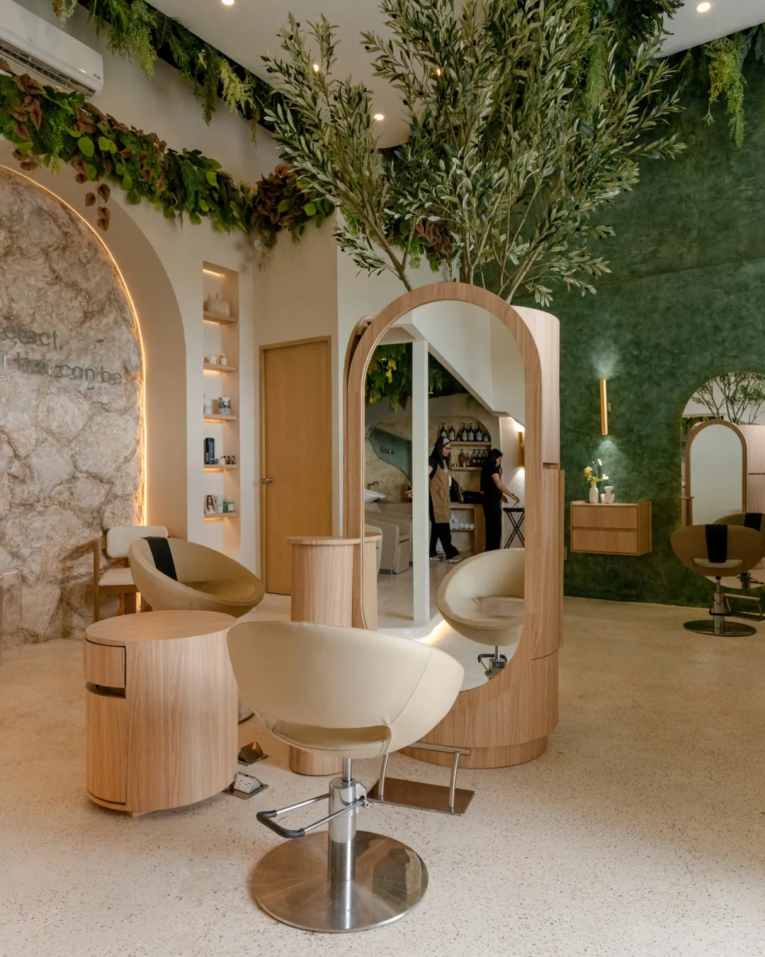 Oliu Hair salon in Cancun with arched mirrors, plants and warm light, photographed by IVAE